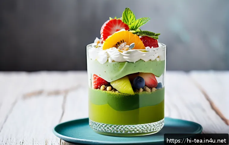 다과와 녹차 디저트 - A close-up shot of a delicate green tea dessert parfait served in a clear glass, layered with smooth...